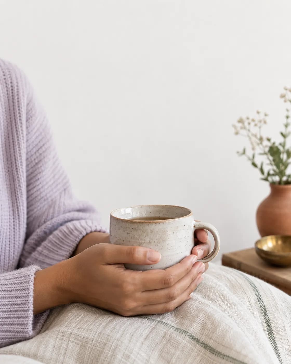 Two hands holding a handmade ceramic mug